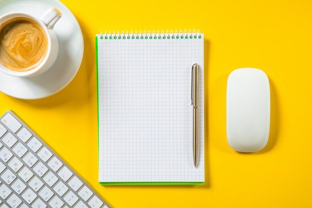 Top view of business working place with cup of coffee, Empty workspace on yellow table.