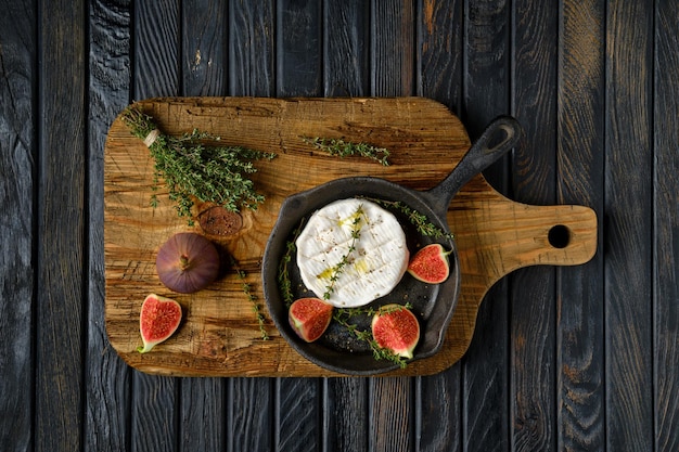 Top view of camembert cheese and figs on frying pan