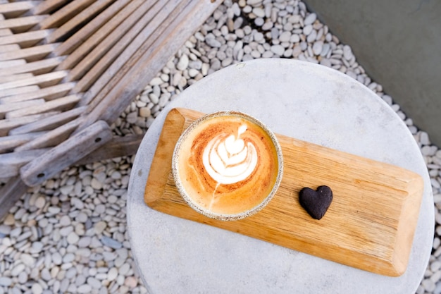 Top view of ceramic cup of cappuccino with beautiful latte art on concrete background