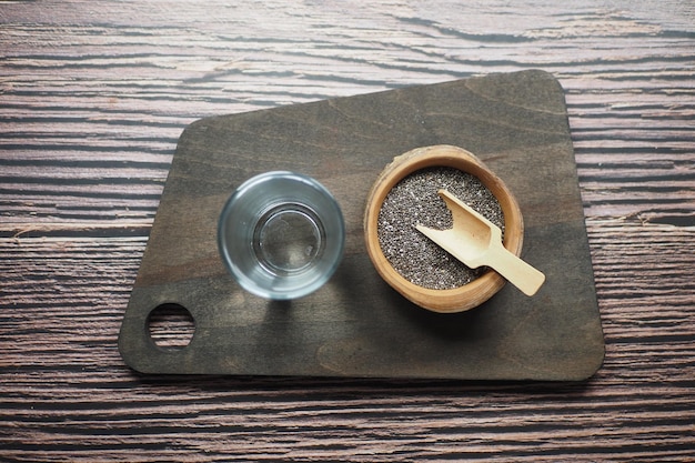 Top view of chia seeds and a glass of water on table