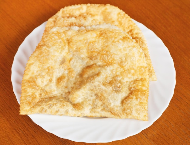 Top view of chiburekki pie on white plate