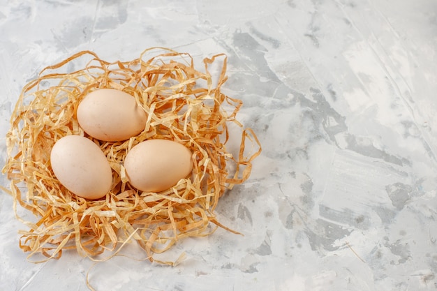 top view chicken eggs on straw on table with copy place