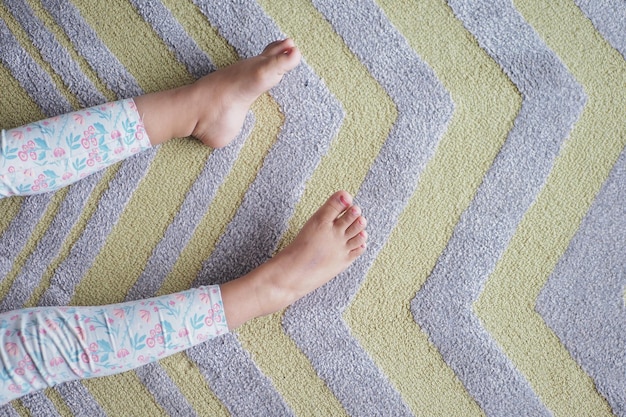 Top view of child bare feet on a carpet