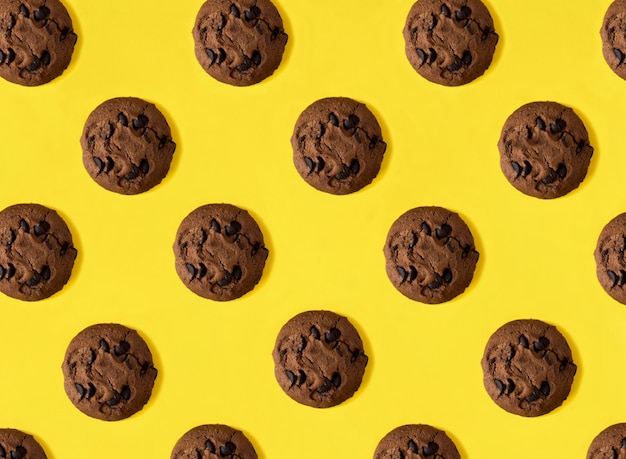 Top view of chocolate cookies on the yellow background Flat lay Pattern