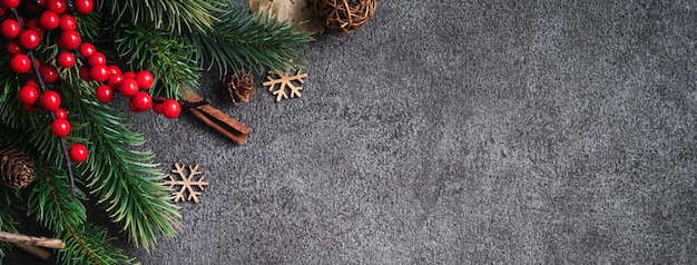 Top view of Christmas background design concept with fir tree branch, snowflake and pine cones.