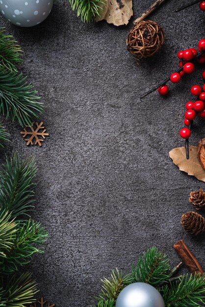 Top view of Christmas background design concept with fir tree branch, snowflake and pine cones.