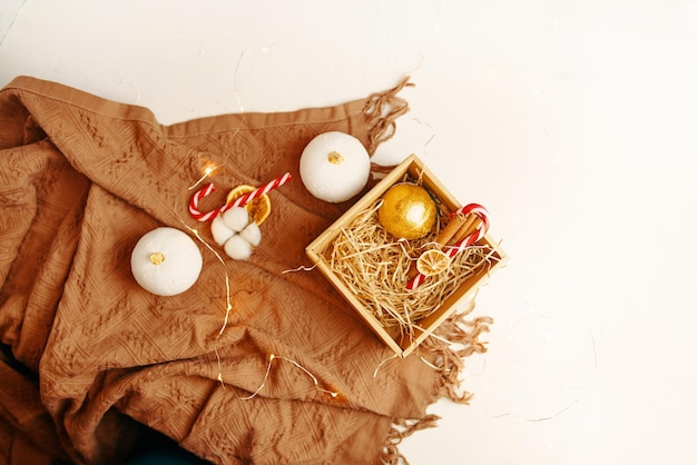 Top view of christmas composition brown warm blanket and gift box with new year golden ball lollipop...