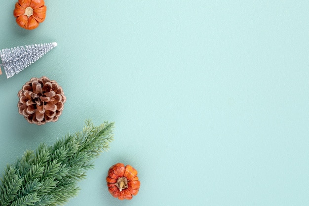 Top view of Christmas holiday decoration ornament composition with Christmas tree, gift star, gingerbread man flat lay with copy space isolated on green background.