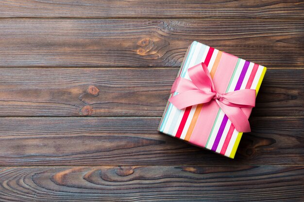 Top view of christmas or other holiday handmade present box package, flat lay dark wooden background with copy space. new year gift box.