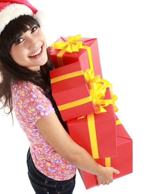 Top view of Christmas woman holding gifts wearing Santa hat. Standing in full body isolated. Smiling woman portrait of a beautiful Asian model.