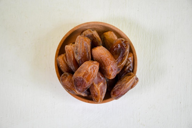 Top view close up dried dates fruit in a bowl for ifthar ramadhan and ied fitr