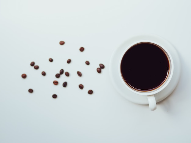 Top view coffee cup and beans on white. Morning coffee with grains flat lay concept