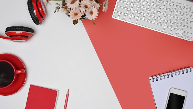 Top view coffee cup headphone smart phone and notebook on red and white background