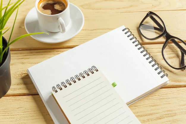 Top view. coffee cup with coffee. pen putting on blank notebook.