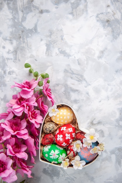 top view colored easter eggs inside heart shaped box with flowers white surface colourful holiday ornate spring concept