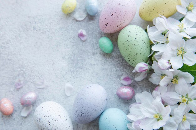 Top view of colorful easter eggs and spring blossom  on concrete background