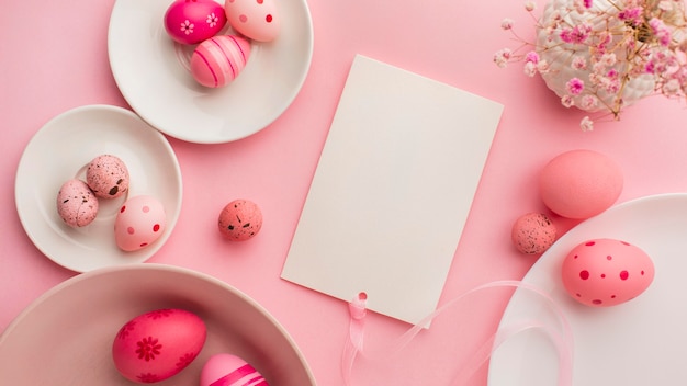 Top view of colorful easter eggs with plates and flowers