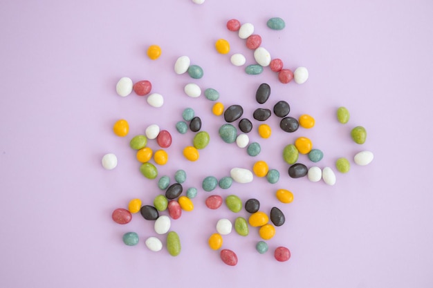 Top view of colorful sweets on violet background with copy space