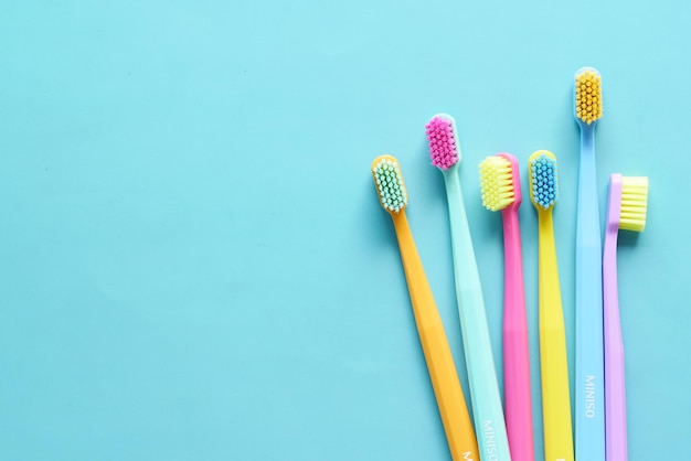 Top view of colorful toothbrushes on light color background