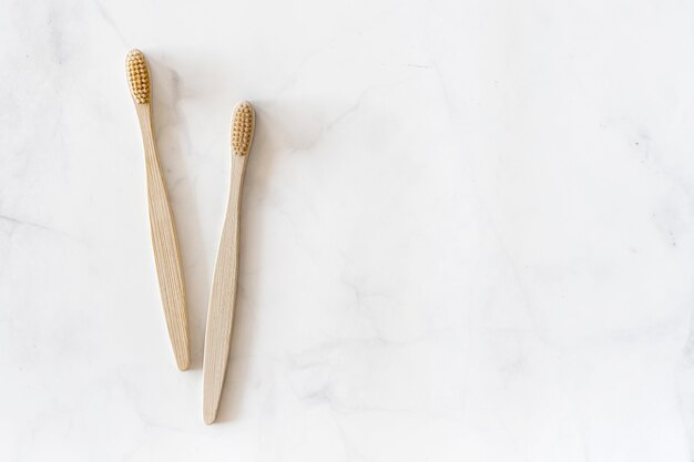 Top view composition with biodegradable bamboo toothbrushes on marble background