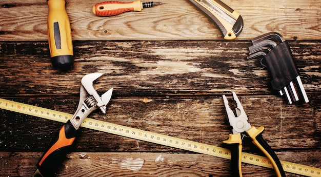 Top view of construction handy tools on wooden background.