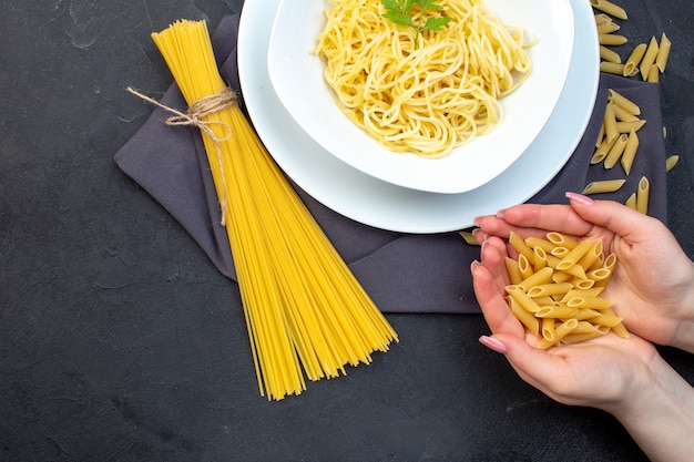 top view cooked italian pasta with raw pasta on dark background food pasta dinner meal cooking color cuisine darkness