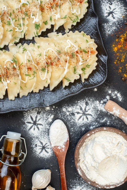 Top view cooked meat dumplings with different ingredients on the dark background vegetable dish cooking meal color dough dinner pepper