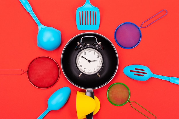 Top view of cooking utensils composition in kitchen isolated on red background