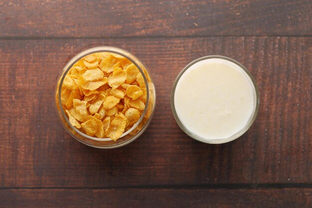 top view of corn flakes and glass of milk on table