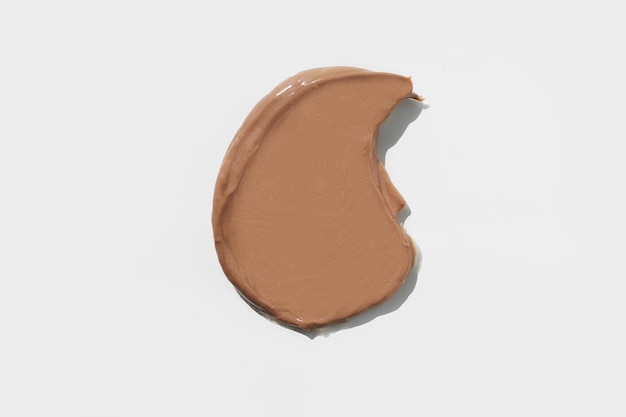 Top view of the cosmetic brown cream on white background different swatches pastel colors good as co