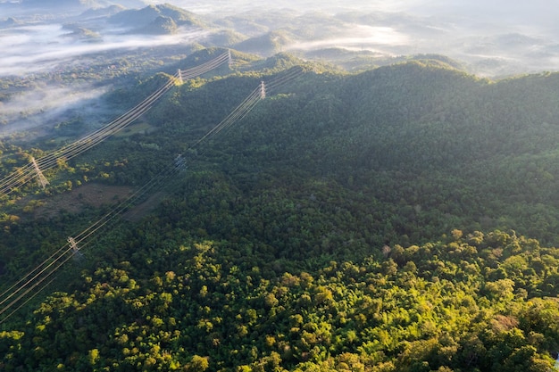 Top view of countryside road passing through the green forrest and mountain