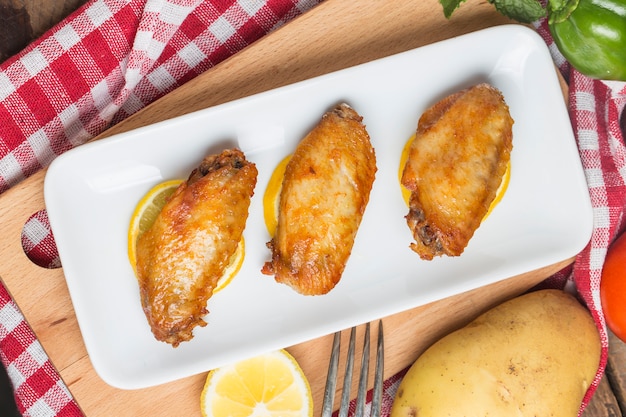 Top view of crispy chicken wings with lemon