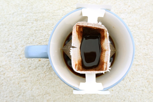 Top View of a Cup of Aromatic Portable Drip Coffee Being Prepared on stone table