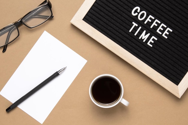 Top view of cup of black coffee and phrase coffee time on letter board