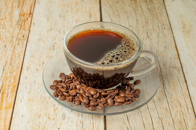 top view cup of coffee with coffee beans over wooden table