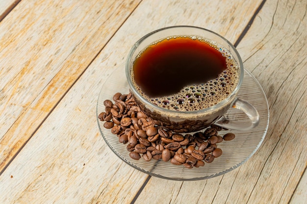 top view cup of coffee with coffee beans over wooden table