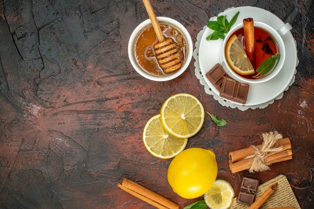 top view cup of tea with fresh yellow lemons and biscuits on dark background color morning sweet breakfast fruit ceremony tea honey