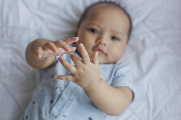 Top view of cute baby smiling to the camera on the bed