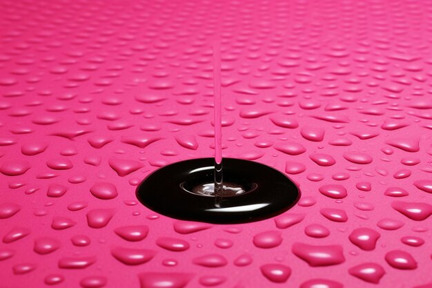 Top view d render of water effect on a pink shiny surface