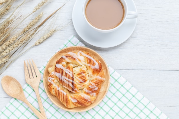 Top view danish pastries and coffee cup on white wooden table background