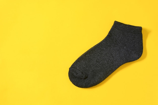 Top view of dark gray color mens socks on yellow background