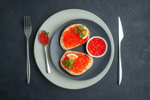 top view delicious caviar sandwiches inside plate with fork and knife on dark surface