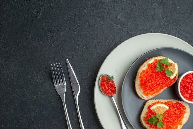 top view delicious caviar sandwiches inside plate with fork and knife on dark surface