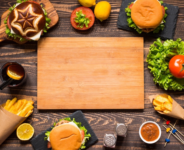 Top view of delicious hamburger, with vegetables,  on a wooden background.