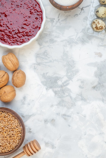 Top view of delicious jam walnuts eggs wheats in a brown pot on ice background with free space