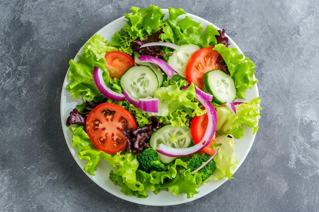 Top view delicious vegetable salad inside plate on a grey background