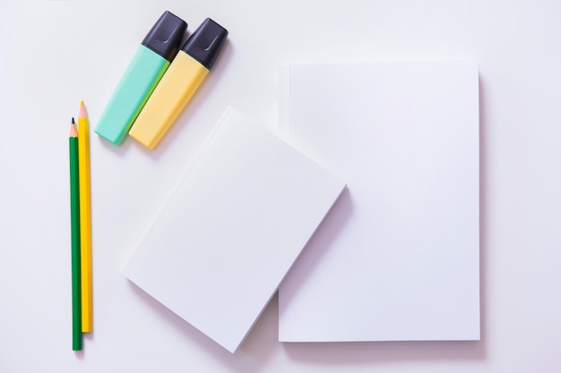 Top view of a desk with colored pencils and blank notebooks Copy space