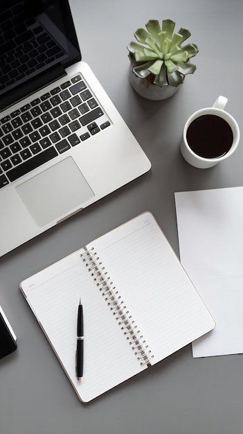 Photo top view of a desk with a laptop a notebook a pen a cup of coffee a plant and a blank sheet of pape