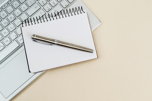 Top view of a desk with laptop notebook and pen