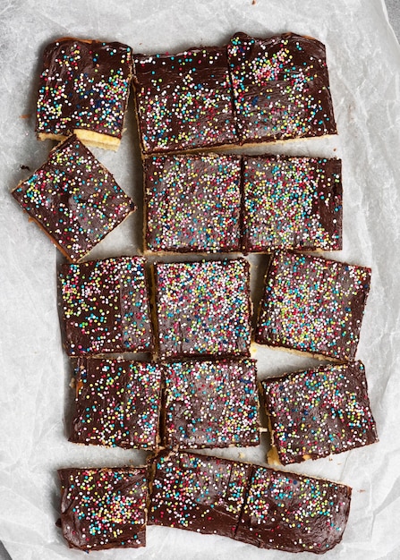 Top view of dessert cake bars with sugar sprinkle over baking paper Sweet food concept for birthday